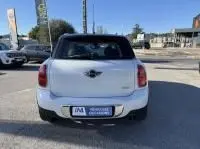 Vue arrière d'une MINI Countryman Cooper 122 Pack Chili blanche de 2012, avec toit noir et feux arrière distinctifs.
