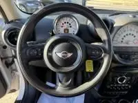 Vue intérieure centrée sur le volant noir de la MINI Countryman Cooper 122 Pack Chili blanche de 2012, tableau de bord visible.