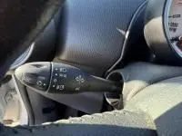 Gros plan sur le commodo de clignotant à gauche du tableau de bord d'une MINI Countryman blanche de 2012.