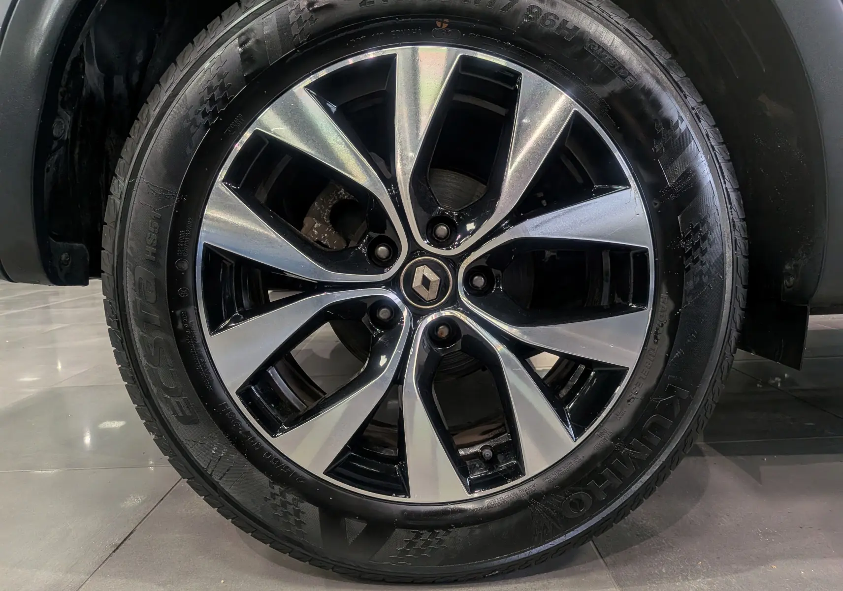 Gros plan sur la roue avant droite du Renault Arkana TCe 140 gris métal avec jante alliage bi-ton 17 pouces.