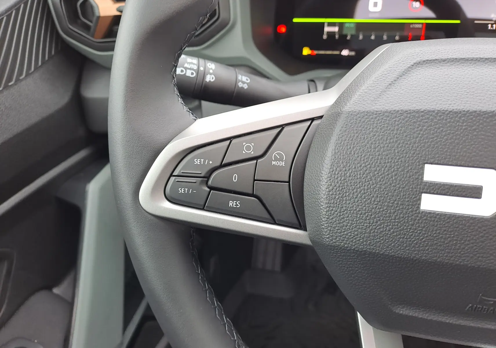 Gros plan sur la partie gauche du volant noir nacré du Dacia Bigster 2025, avec commandes de régulateur de vitesse visibles.