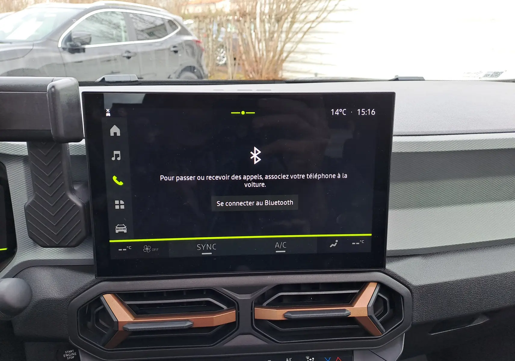 Vue intérieure centrée sur l'écran tactile du tableau de bord du Dacia Bigster 2025 avec aérateurs noirs et bronze.