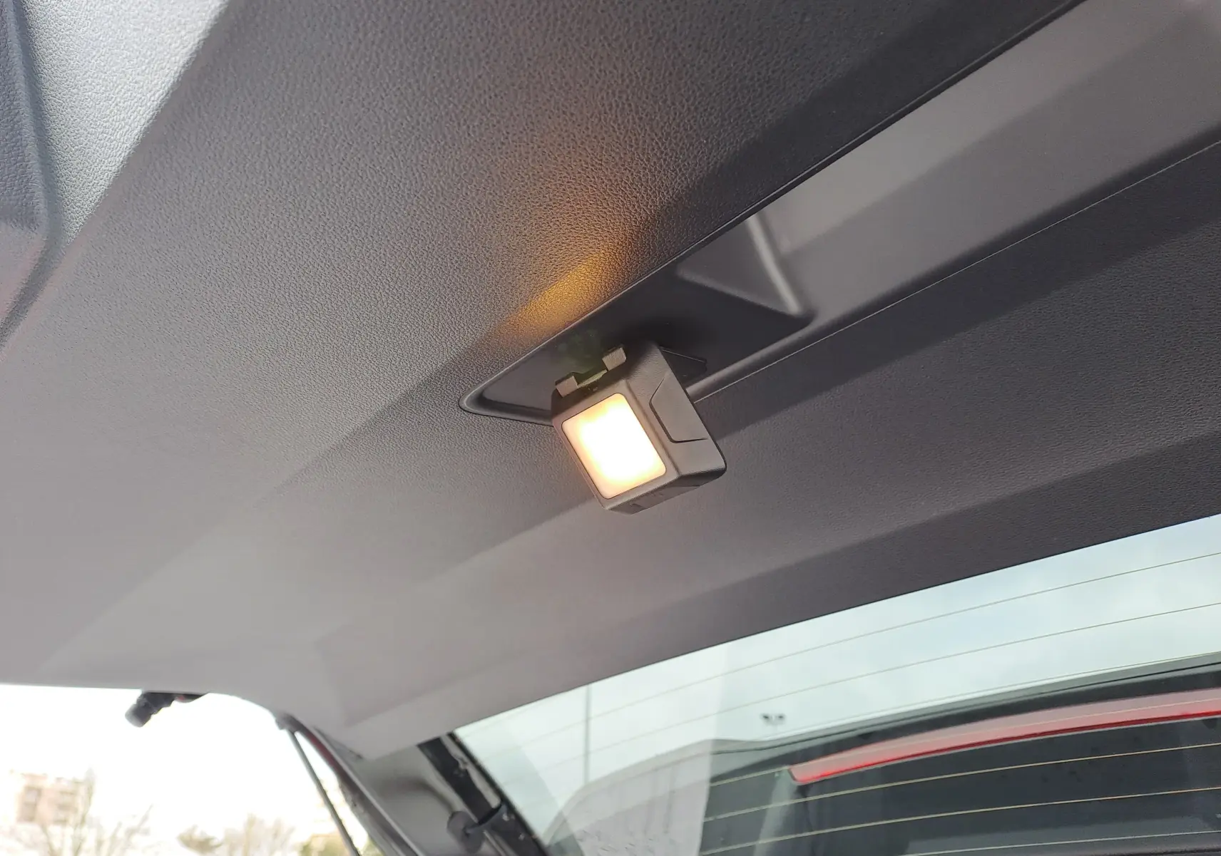 Éclairage intérieur allumé sur le hayon du Dacia Bigster noir nacré, vue partielle depuis l’arrière ouvert.