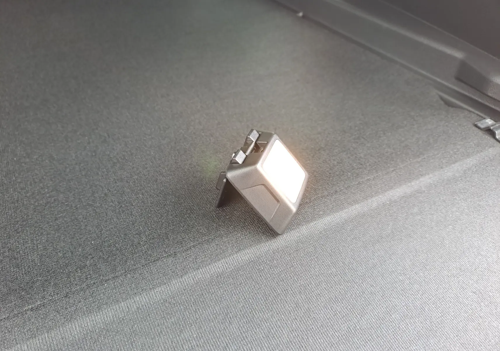 Détail de la lumière intérieure allumée sur le coffre du Dacia Bigster noir nacré, vue rapprochée.