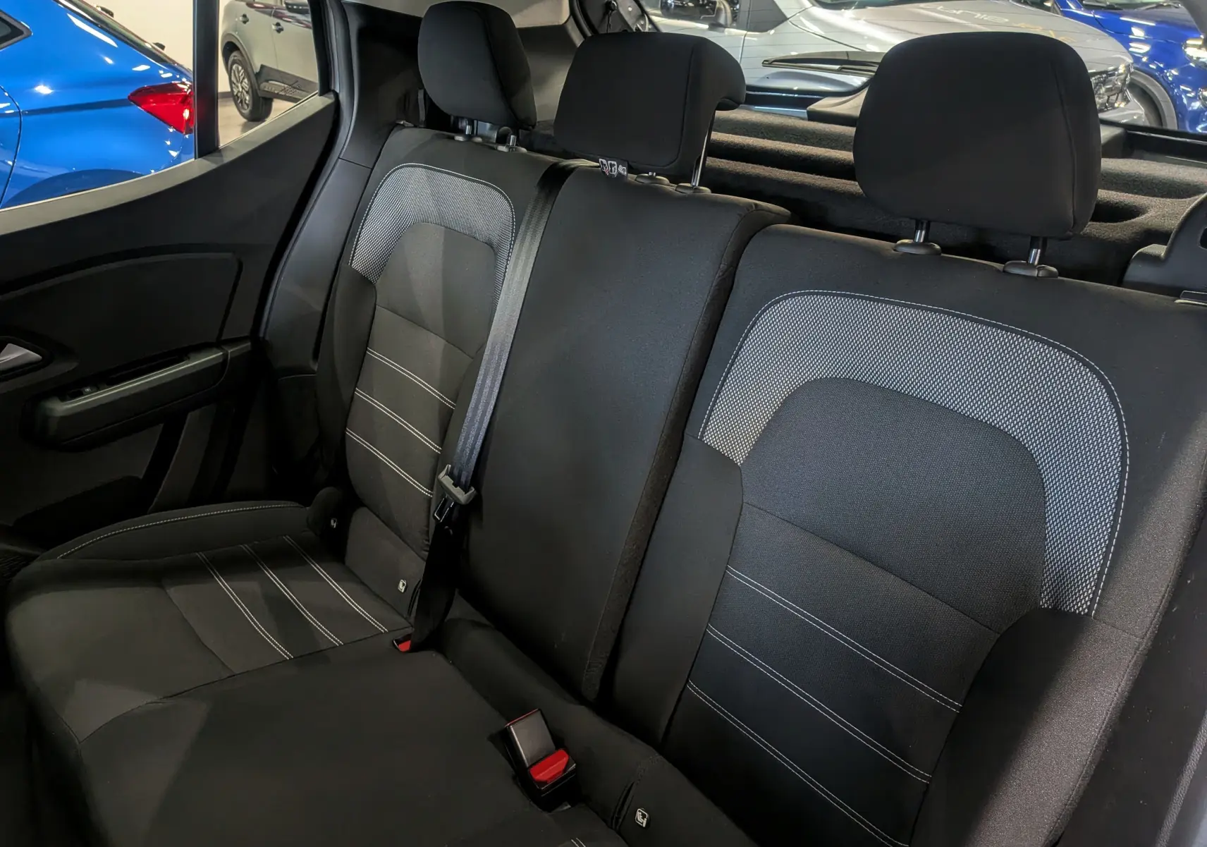 Vue intérieure sur les sièges arrière en tissu noir avec surpiqûres grises de la Dacia Sandero TCe 90 CH Journey 2025.