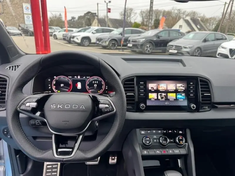 Vue intérieure du tableau de bord et volant SKODA KAROQ gris diamant, avec écran tactile central et affichage numérique.