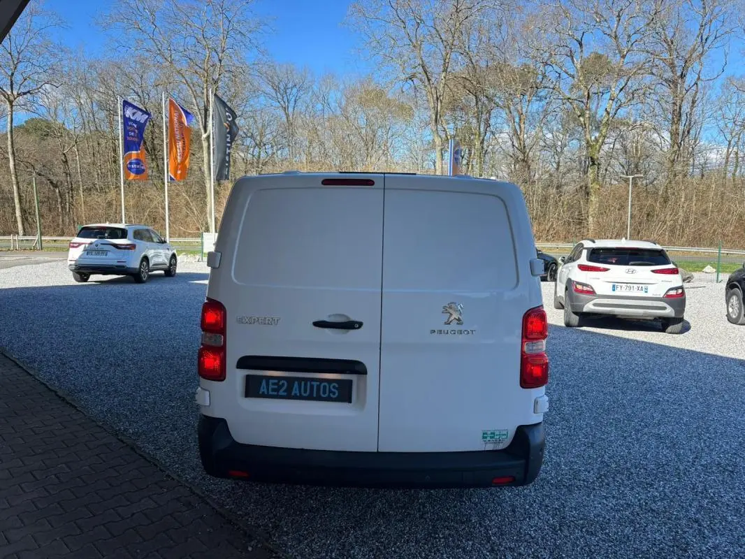 Vue arrière d’un Peugeot Expert Fourgon blanc 2018 avec portes battantes et feux rouges visibles.
