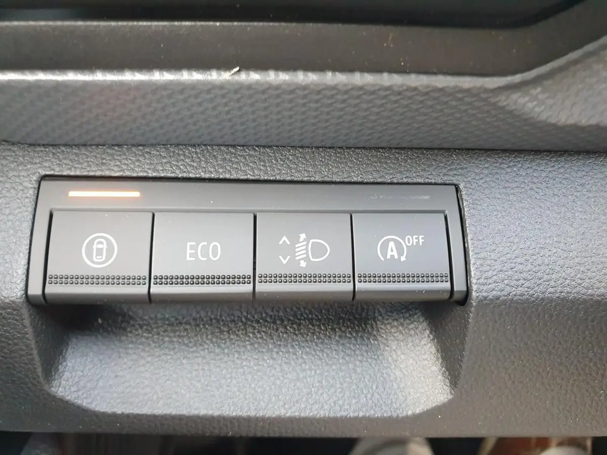 Gros plan sur les boutons de commande du tableau de bord du Dacia Duster 2026, finition gris schiste.