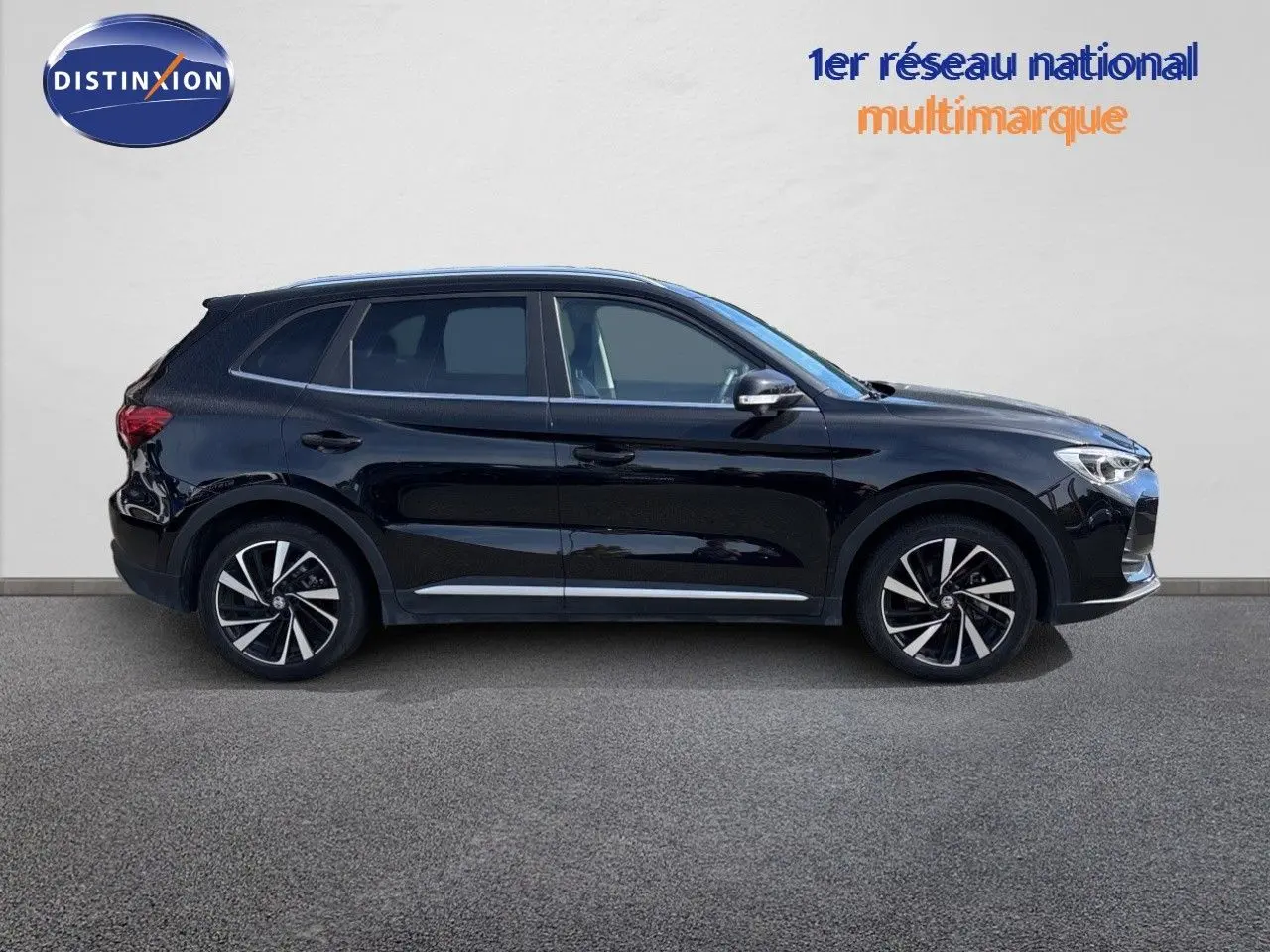 Vue latérale droite du MG MOTOR ZS 1.5L HYBRID+ 197CH LUXURY en noir Pebble Black Metal avec jantes alliage bicolores.
