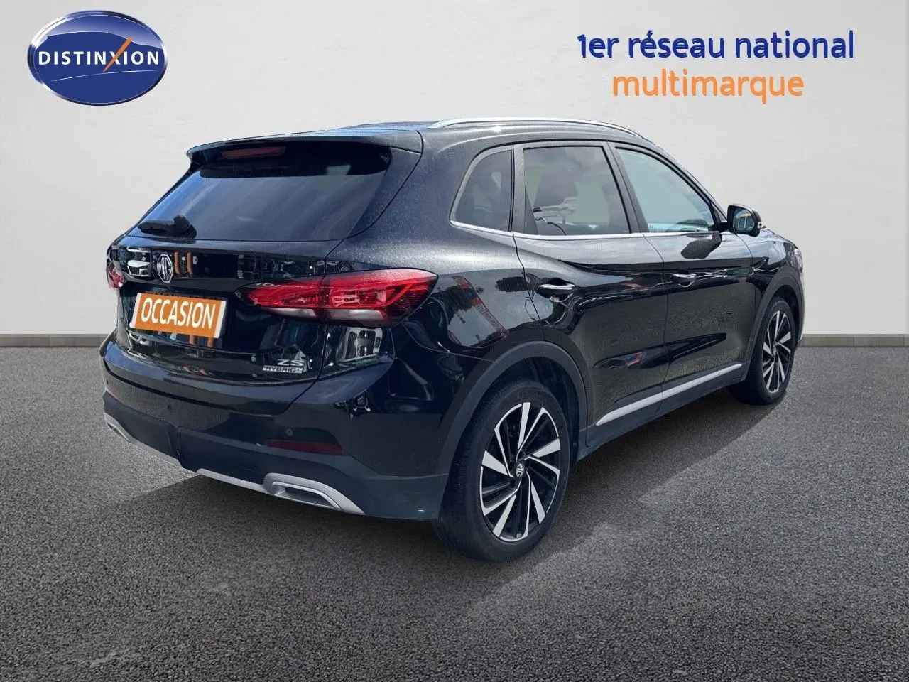 Vue 3/4 arrière droite du MG ZS 1.5L Hybrid+ 197ch Luxury en noir Pebble Black Metal avec jantes alliage bicolores.