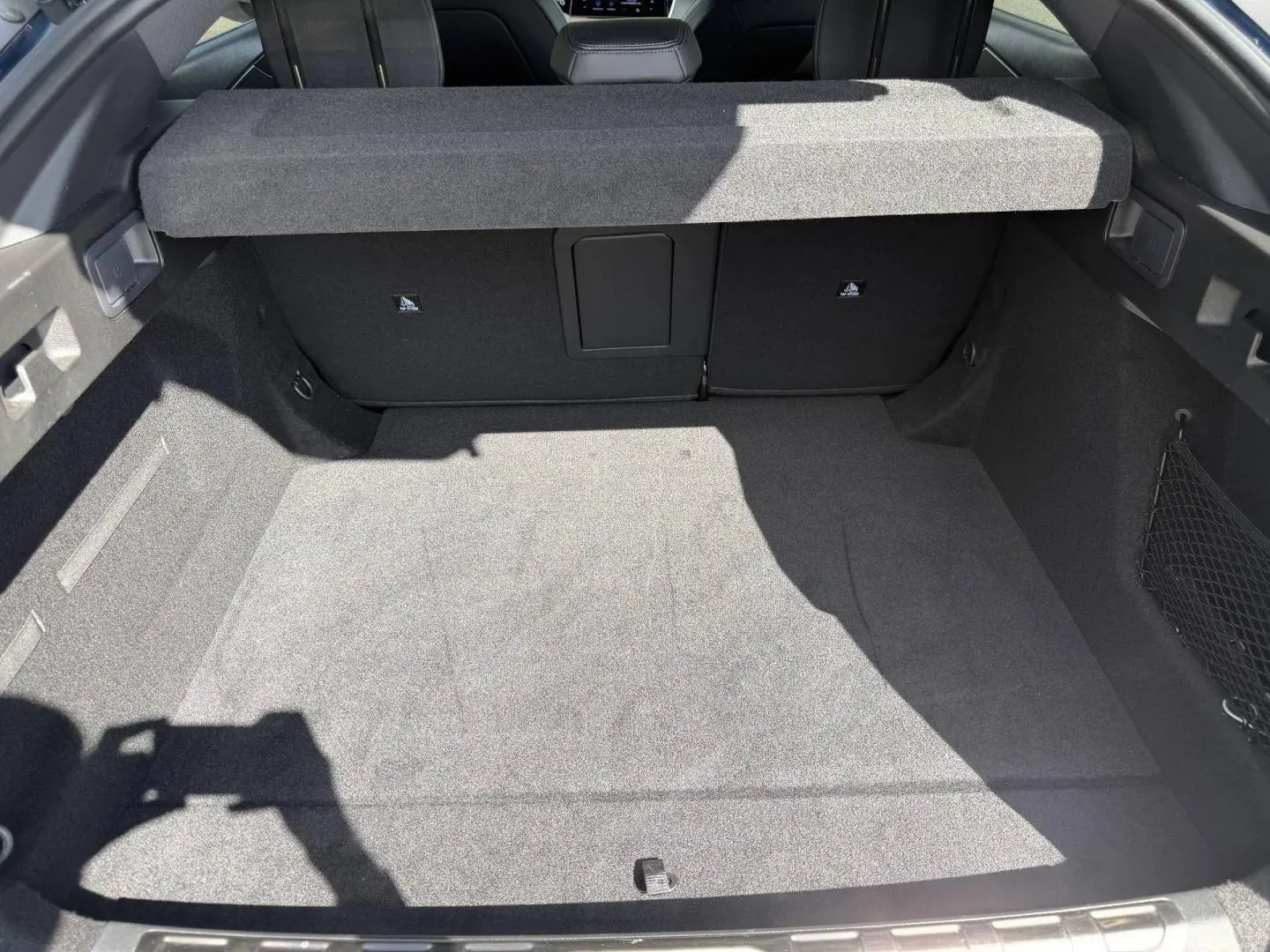 Vue intérieure du coffre spacieux et propre de la Peugeot 408 Hybrid 145ch GT, avec cache-bagages en place.