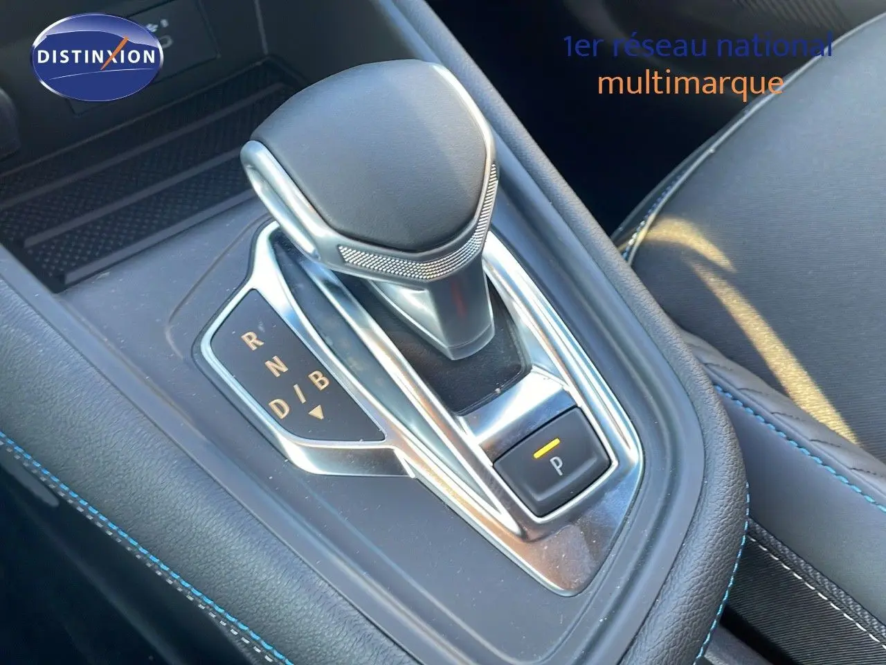 Le levier de vitesses automatique du Renault Captur E-Tech hybride, avec surpiqûres bleues visibles sur la console.