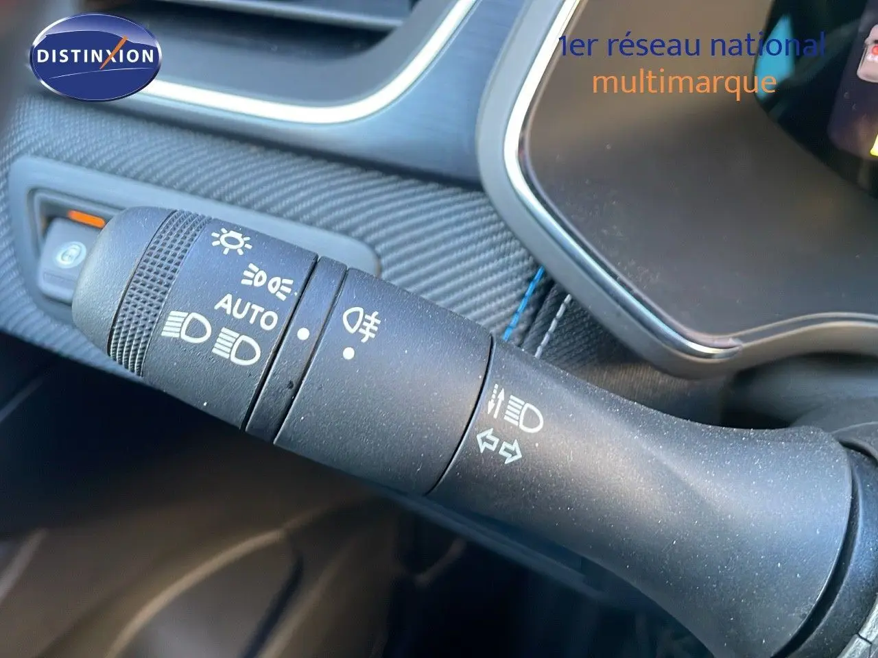 Gros plan sur la commande des phares et clignotants du Renault Captur E-Tech hybride 2025, intérieur noir.