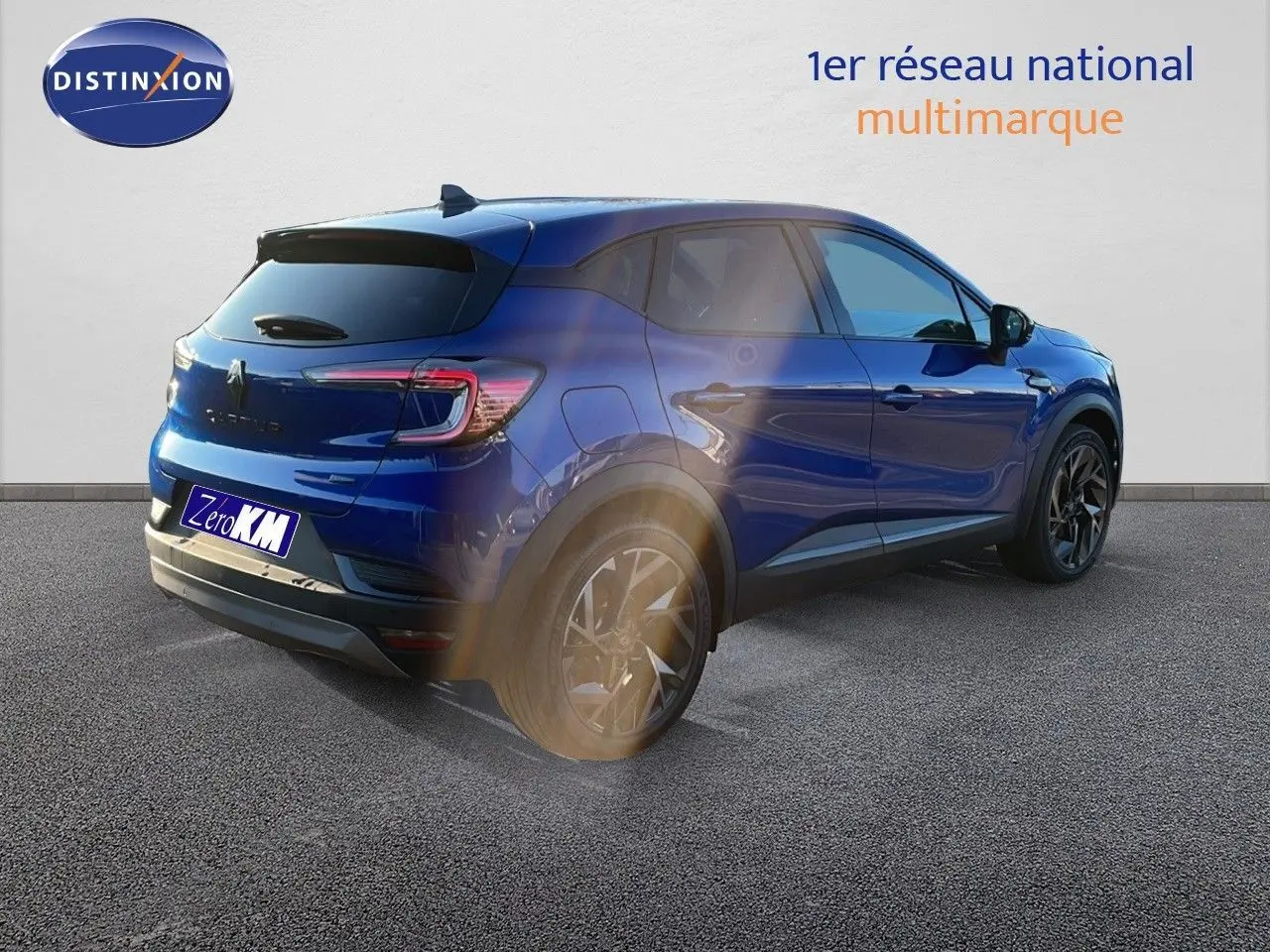 Vue 3/4 arrière droite du Renault Captur E-Tech hybride bleu Iron Metal avec jantes noires et toit noir contrasté.