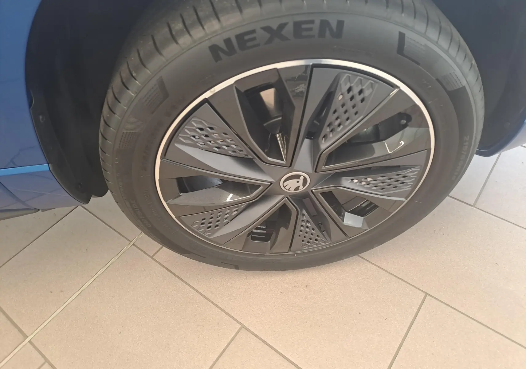 Gros plan sur la roue avant gauche du Skoda Karoq Bleu RS 2025 avec jante noire au design moderne.