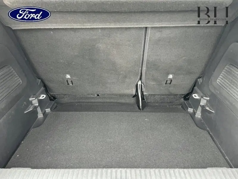 Coffre vu de l'intérieur d'un Citroën C3 Aircross 2019 blanc, avec banquette arrière rabattue et revêtement noir.