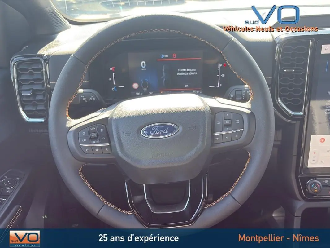 Vue rapprochée du volant multifonctions noir du Ford Ranger 2025 avec tableau de bord numérique et commandes intégrées.