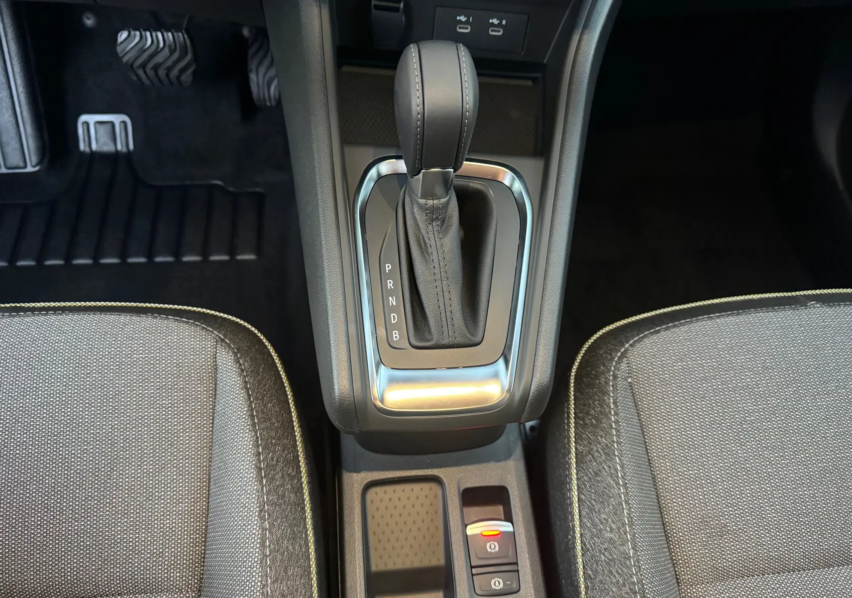 Vue plongeante sur la console centrale du Renault Captur E-Tech, avec levier de vitesse automatique et sièges tissu gris.