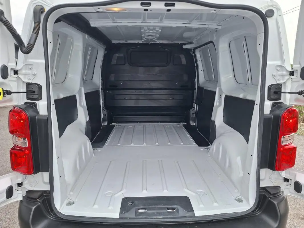 Vue arrière du fourgon Opel Vivaro blanc 2025, montrant l'espace de chargement vide et les portes ouvertes.