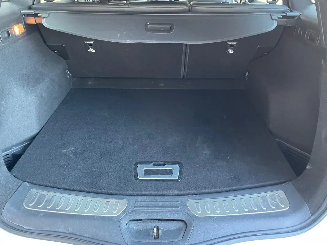 Vue arrière du coffre noir du Renault Koleos blanc 2019, avec cache-bagages et seuil de chargement visible.