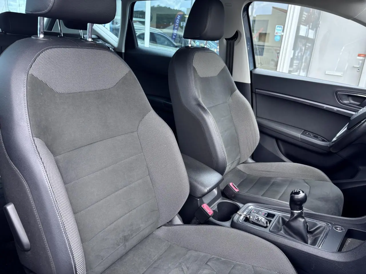 Vue intérieure côté droit montrant les sièges textile gris et la console centrale avec levier de vitesses manuel du SEAT Ateca 2019.