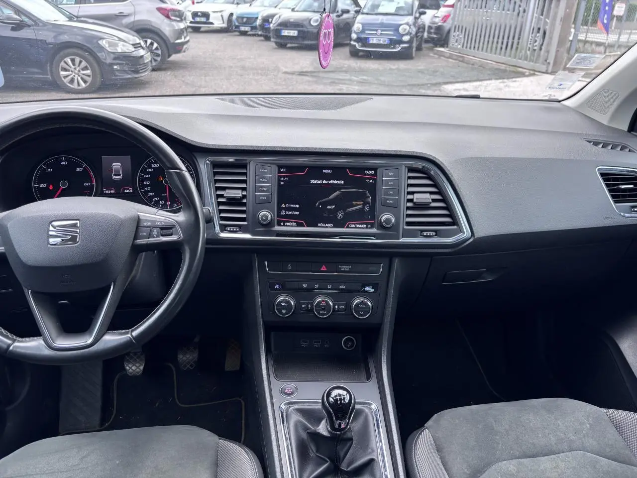 Vue intérieure avant du tableau de bord et volant cuir d'une SEAT Ateca gris foncé avec boîte manuelle et écran tactile central.