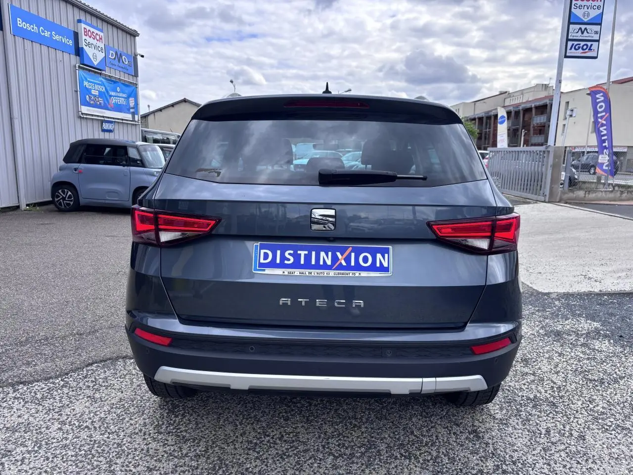 Vue arrière d'un SEAT Ateca gris foncé avec feux LED et plaque d'immatriculation Distinxion visible en extérieur.