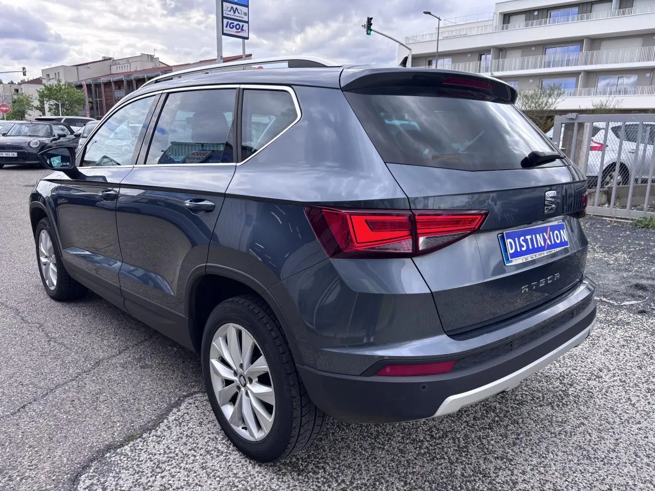 Vue 3/4 arrière droite d'un SEAT Ateca gris foncé avec jantes alliage et feux arrière LED, stationné en extérieur.