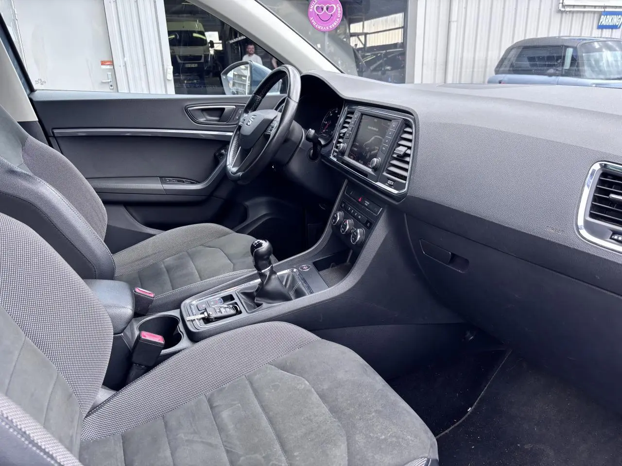 Intérieur avant droit du SEAT Ateca gris foncé, montrant tableau de bord, volant cuir et console centrale avec boîte manuelle.