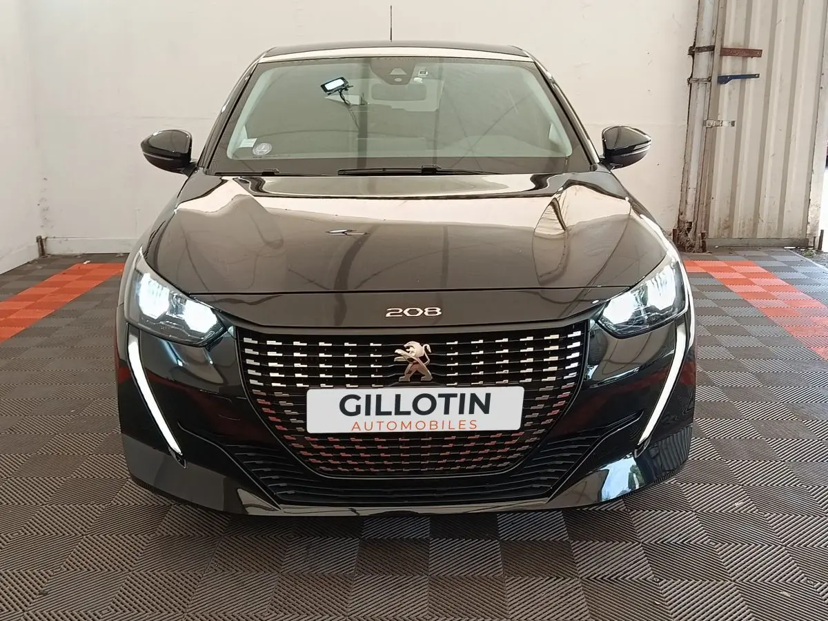 Vue frontale d'une Peugeot 208 PureTech 100 S&S Style noire avec phares LED allumés et calandre distinctive.