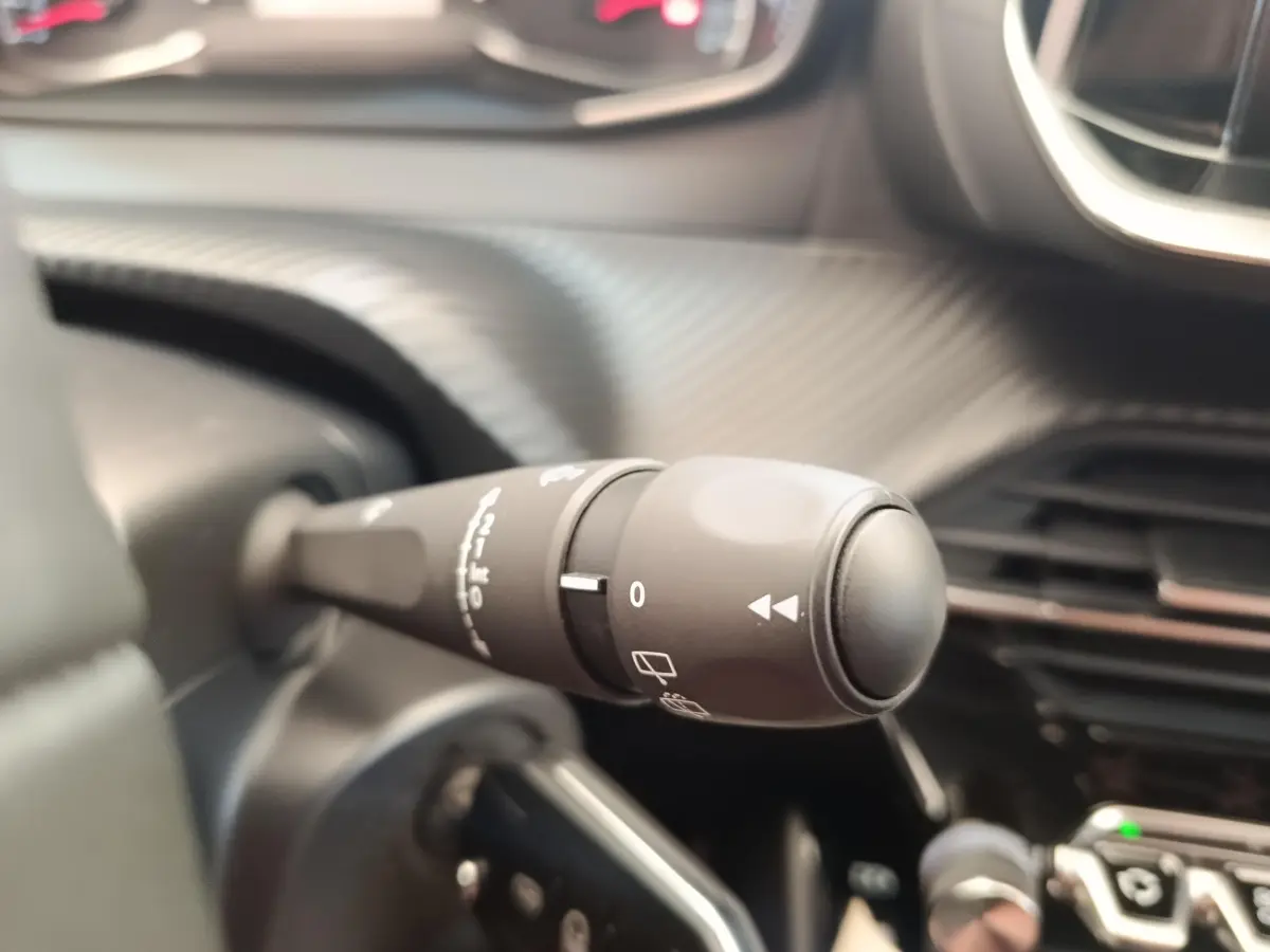 Gros plan sur la commande d’essuie-glace noire dans l’habitacle d’une Peugeot 208 PureTech 100 S&S Style 2022.