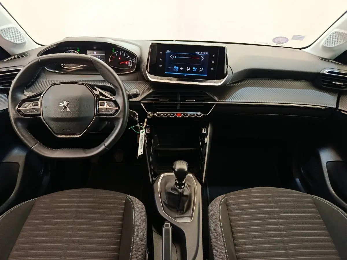 Intérieur Peugeot 208 PureTech 100 S&S Style 2022, vue avant centrée sur volant cuir, tableau de bord et écran tactile.
