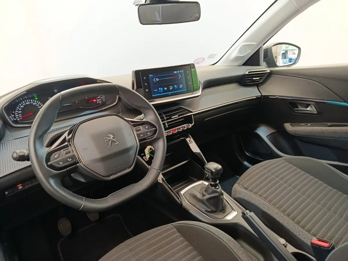 Intérieur de la Peugeot 208 PureTech 100 S&S Style 2022, vue côté conducteur, volant cuir et écran tactile central.