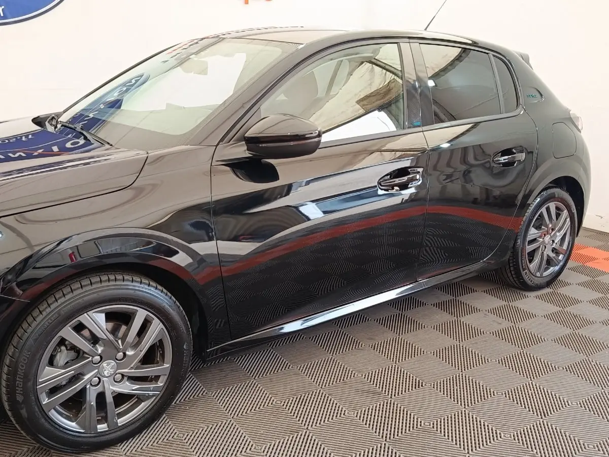 Vue latérale droite d'une Peugeot 208 PureTech 100 S&S Style noire avec jantes alliage et poignées chromées.