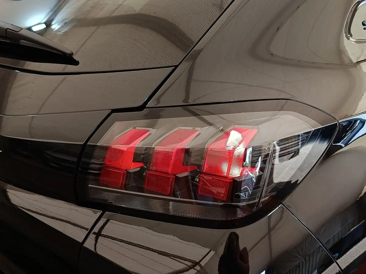 Gros plan sur le feu arrière droit rouge d’une Peugeot 208 PureTech 100 S&S Style noire de 2022.