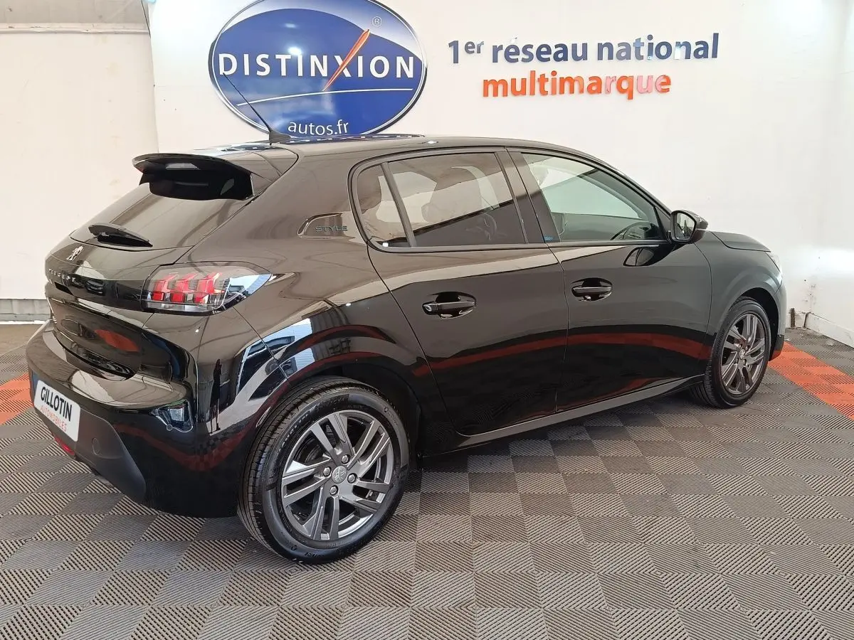 Peugeot 208 PureTech 100 S&S Style noir vue 3/4 arrière droit en intérieur avec jantes alliage et feux LED distinctifs.
