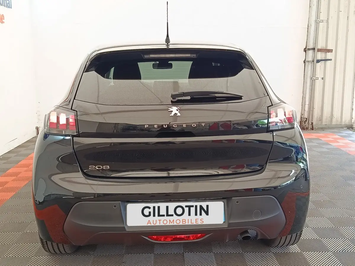 Vue arrière d'une Peugeot 208 PureTech 100 S&S Style noire, avec feux LED et logo lion centré sur le hayon.