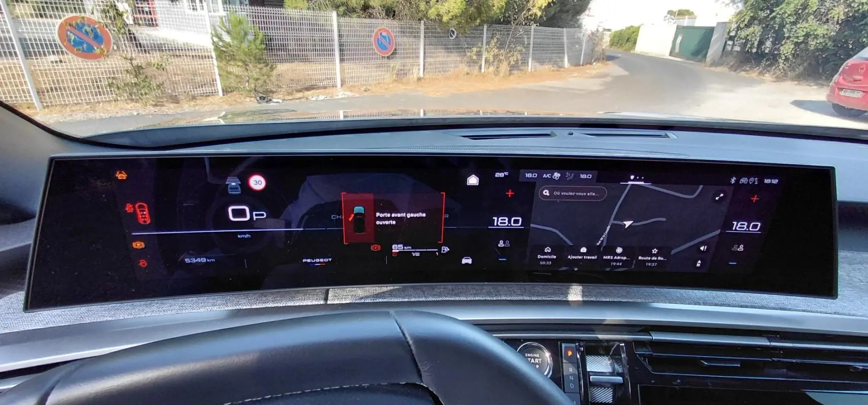 Vue intérieure du tableau de bord numérique du Peugeot 5008 gris 2025, affichant la navigation et alertes portes ouvertes.