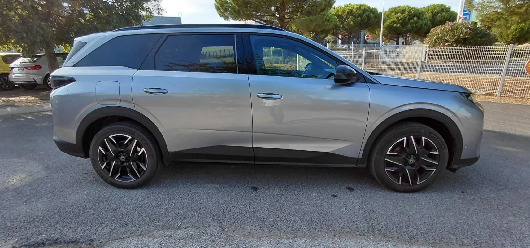Peugeot 5008 gris vue de profil côté gauche, soulignant ses jantes noires et lignes modernes.