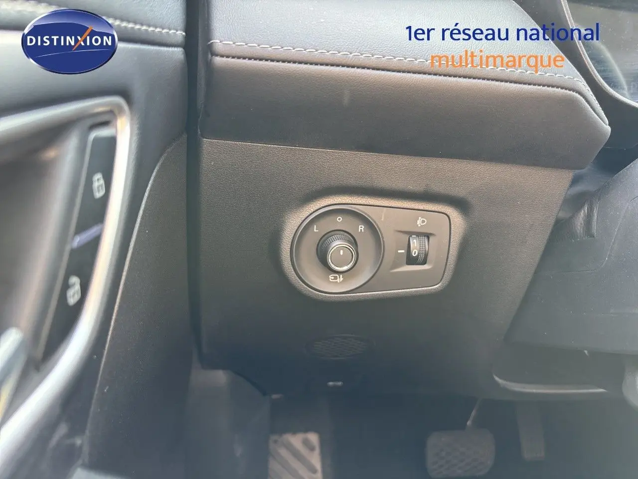 Détail du tableau de bord côté gauche avec commande des rétroviseurs et réglage des phares du MG Motor ZS 2025 noir.