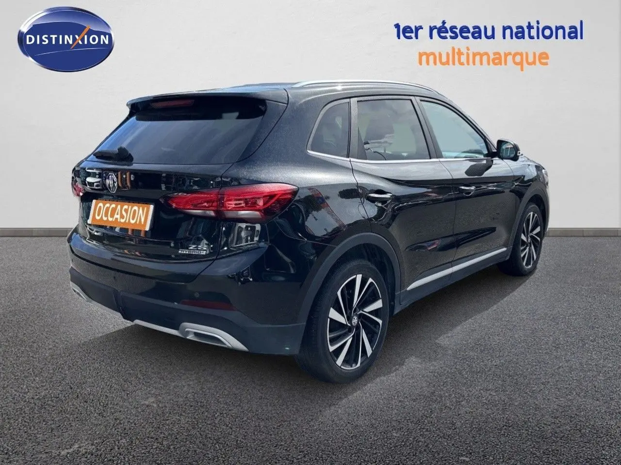 Vue 3/4 arrière droite du MG ZS 1.5L HYBRID+ 197CH Luxury noir Pebble Black Metal avec jantes alliage bicolores.