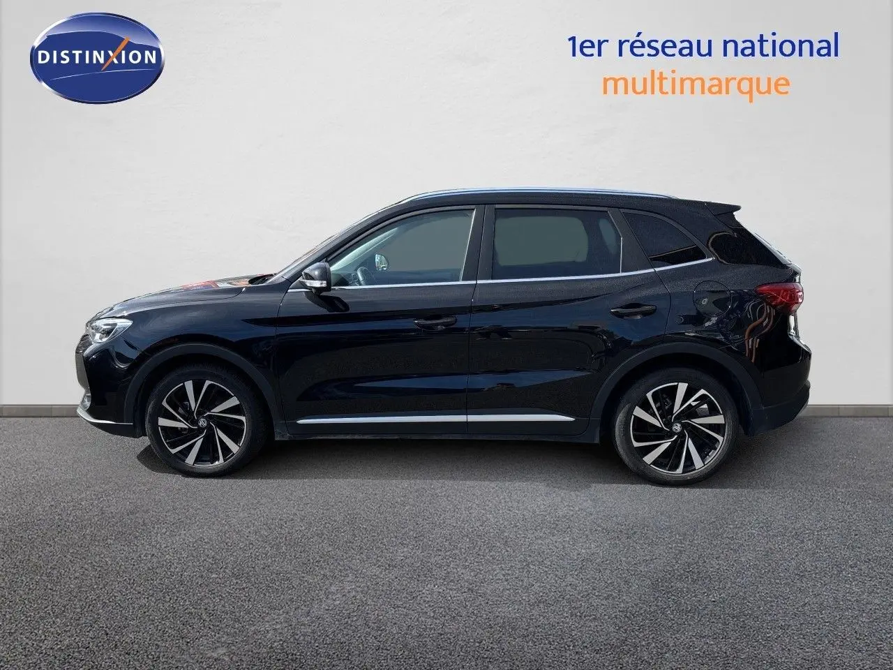 Vue latérale gauche du MG ZS 1.5L HYBRID+ 197CH Luxury en Pebble Black Metal avec jantes alliage bicolores.