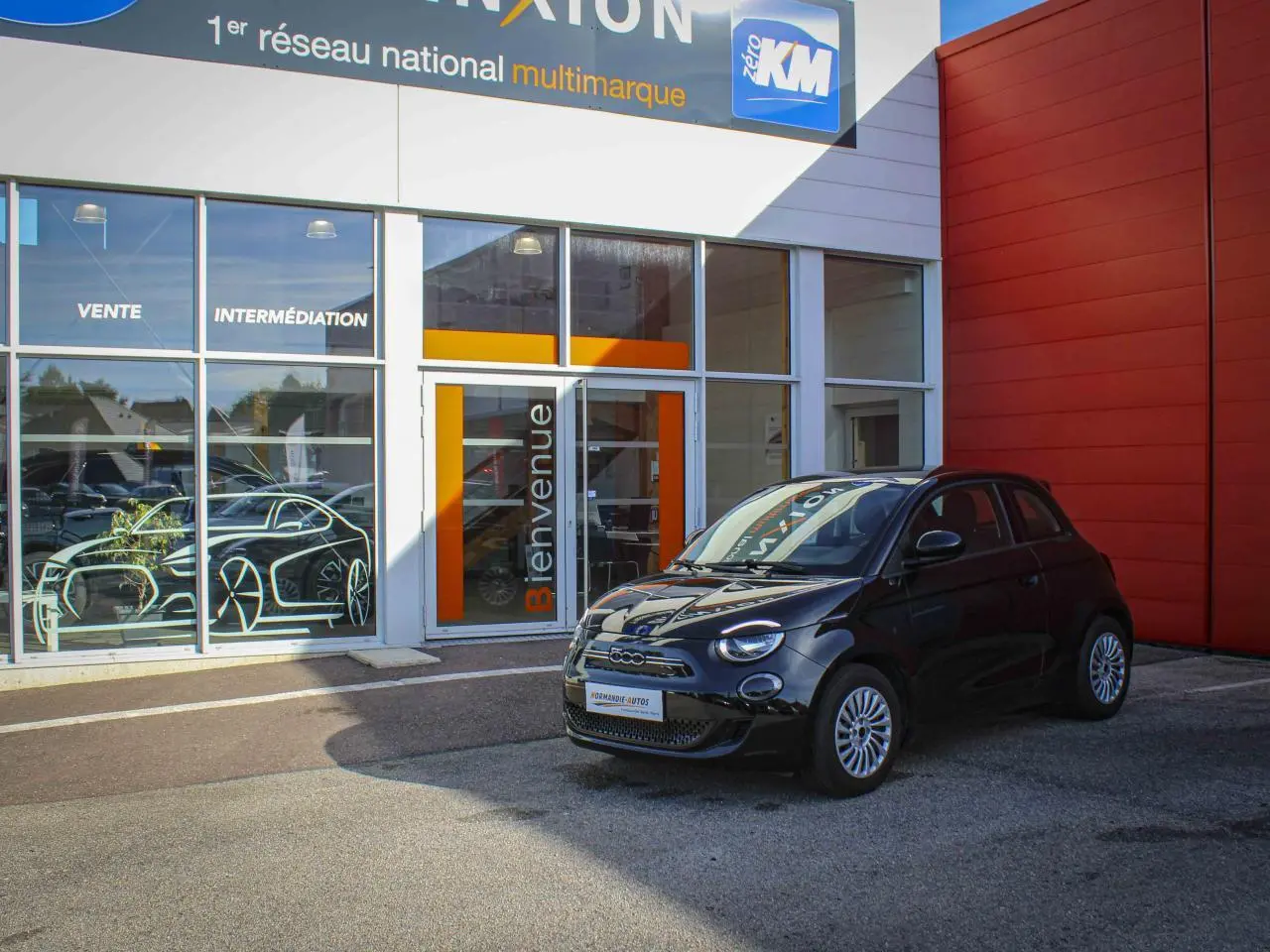 Fiat 500 électrique noire vue en 3/4 avant droit, avec jantes alliage et détails chromés sur calandre.