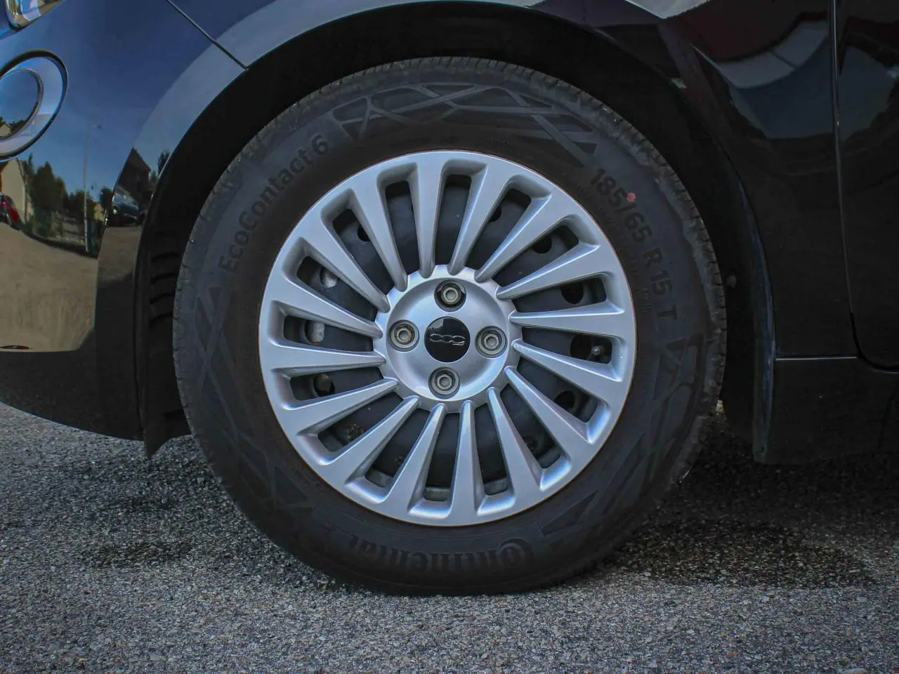 Gros plan sur la jante alliage 15 pouces argentée avec logo 500 au centre du Fiat 500 noir électrique.