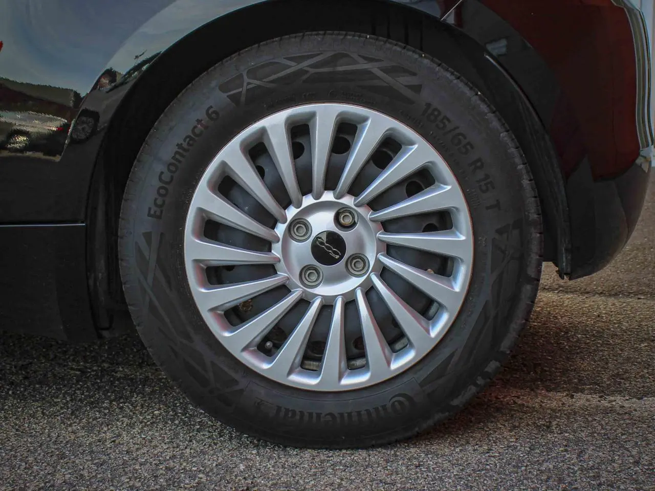 Gros plan sur la jante alliage 15 pouces argentée avec logo 500 centrale de la Fiat 500 noire électrique.