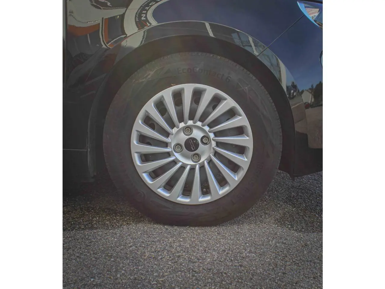 Gros plan sur la roue arrière droite de la Fiat 500 électrique noire avec jante alliage 16 pouces Icône.