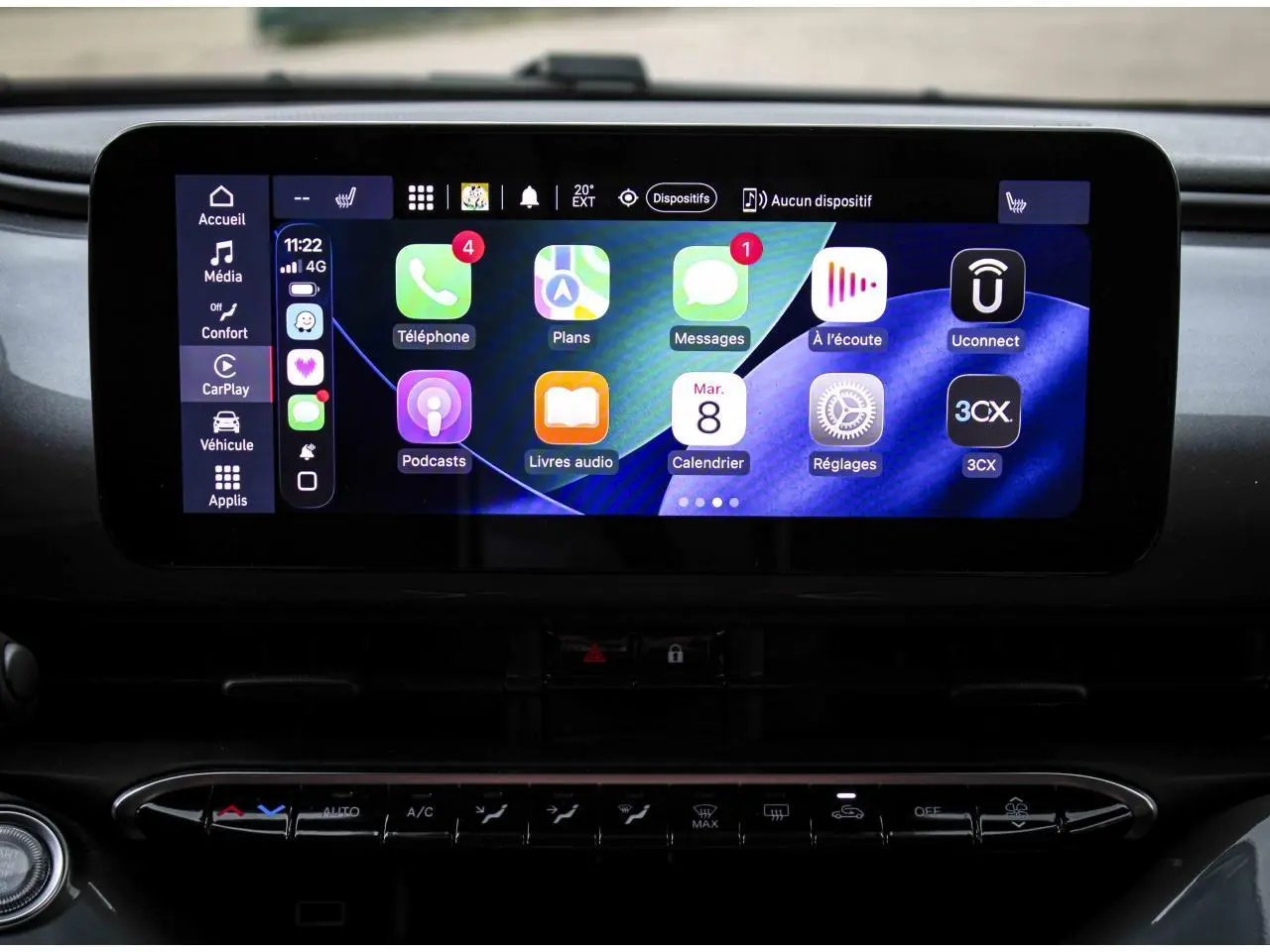 Écran tactile central de la Fiat 500 électrique 2023 affichant l'interface Uconnect avec applications connectées.