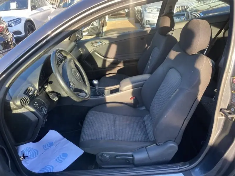 Intérieur de la Mercedes Classe C Coupé Sport 220 CDI 2008, vue côté conducteur, sièges tissu gris et volant cuir.
