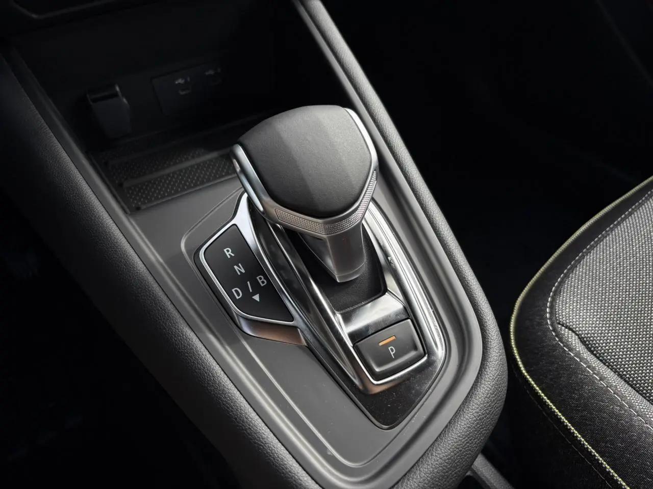 Le levier de vitesses automatique de la Renault SYMBIOZ E-Tech en gros plan, entouré de cuir noir et tissu gris.