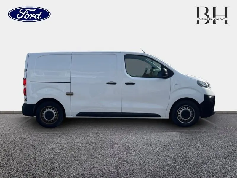 Vue latérale droite d'un utilitaire blanc banquise, fourgon compact avec portes latérales et arrière battantes.